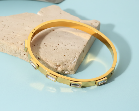 18k gold plated stainless steel bangle with elegant rectangular accents against a light blue background