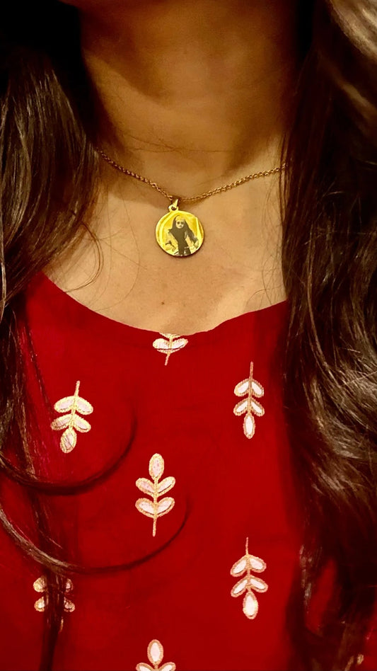 Custom round pendant necklace from Lustre of Love showcasing a unique design worn on a red outfit