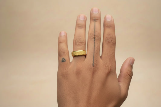 Lustre of Love gold stainless steel ring showcased on a hand with stylish tattoos