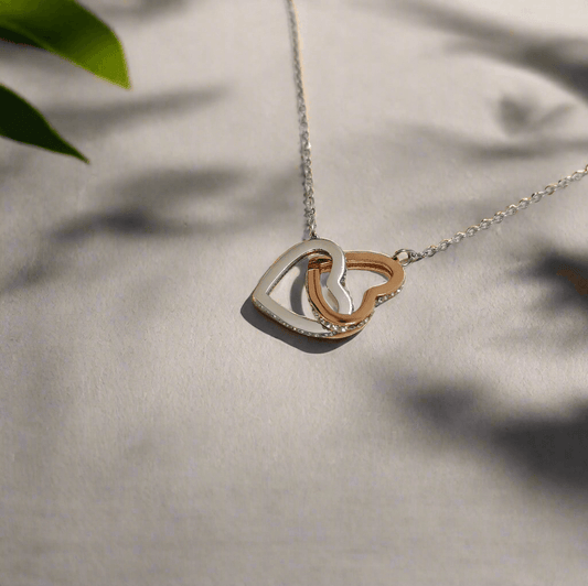 Delicate interlock hearts necklace with silver and rose gold hearts on a fine chain