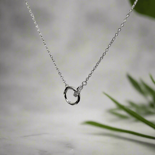 Lustre of Love silver interlocked ring pendant necklace with delicate chain on blurred background
