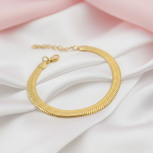 14k gold plated snake chain bracelet with sleek design on soft fabric backdrop