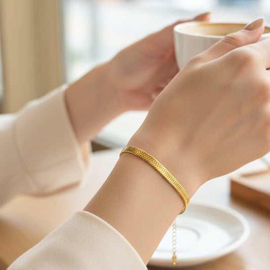 Elegant 14k gold plated snake chain bracelet worn elegantly on a wrist with a coffee cup