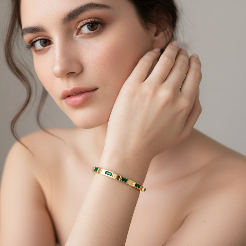 Model wearing an 18k gold plated green zircon bangle, showcasing sleek and elegant design