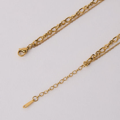 Close-up of an 18k gold plated layered necklace showcasing intricate chain details and lobster clasp