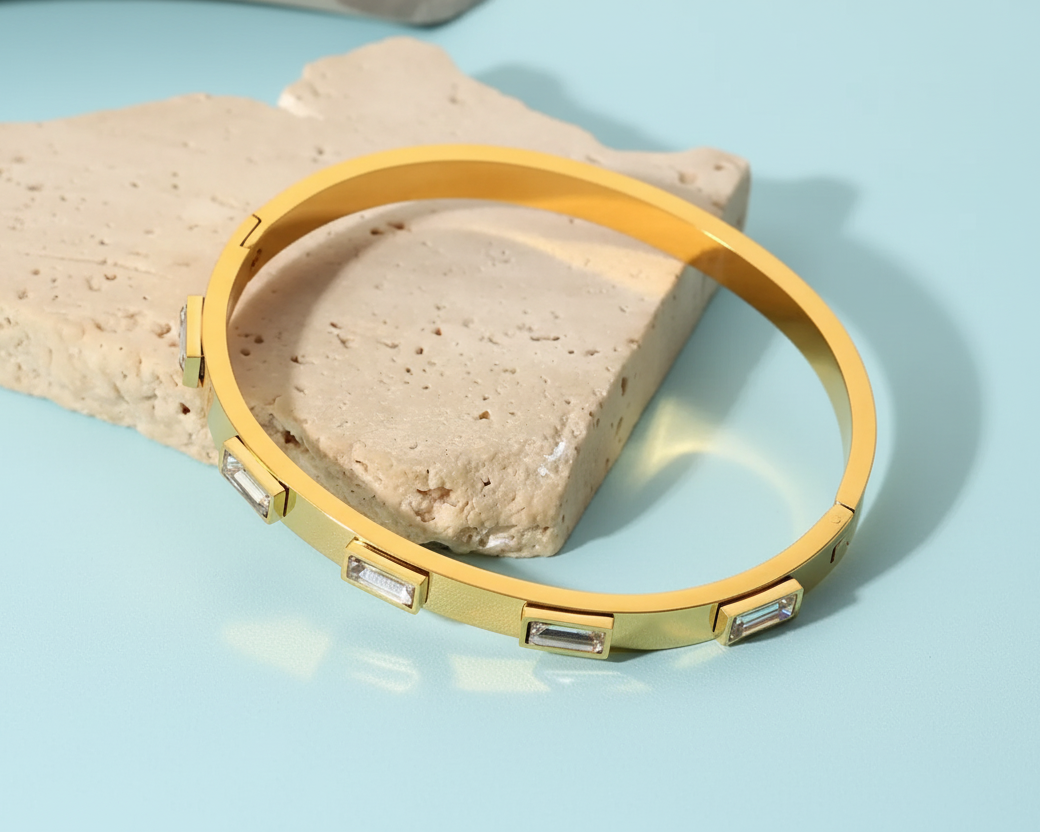 18k gold plated stainless steel bangle with elegant rectangular accents against a light blue background