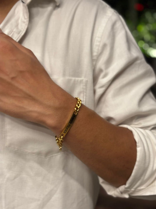 Lustre of Love gold bar bracelet on male wrist with polished curb chain and engraved bar detail