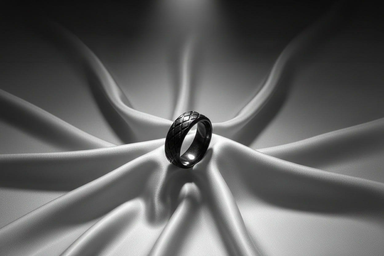 Elegant black stainless steel ring featuring a woven design on a soft satin backdrop