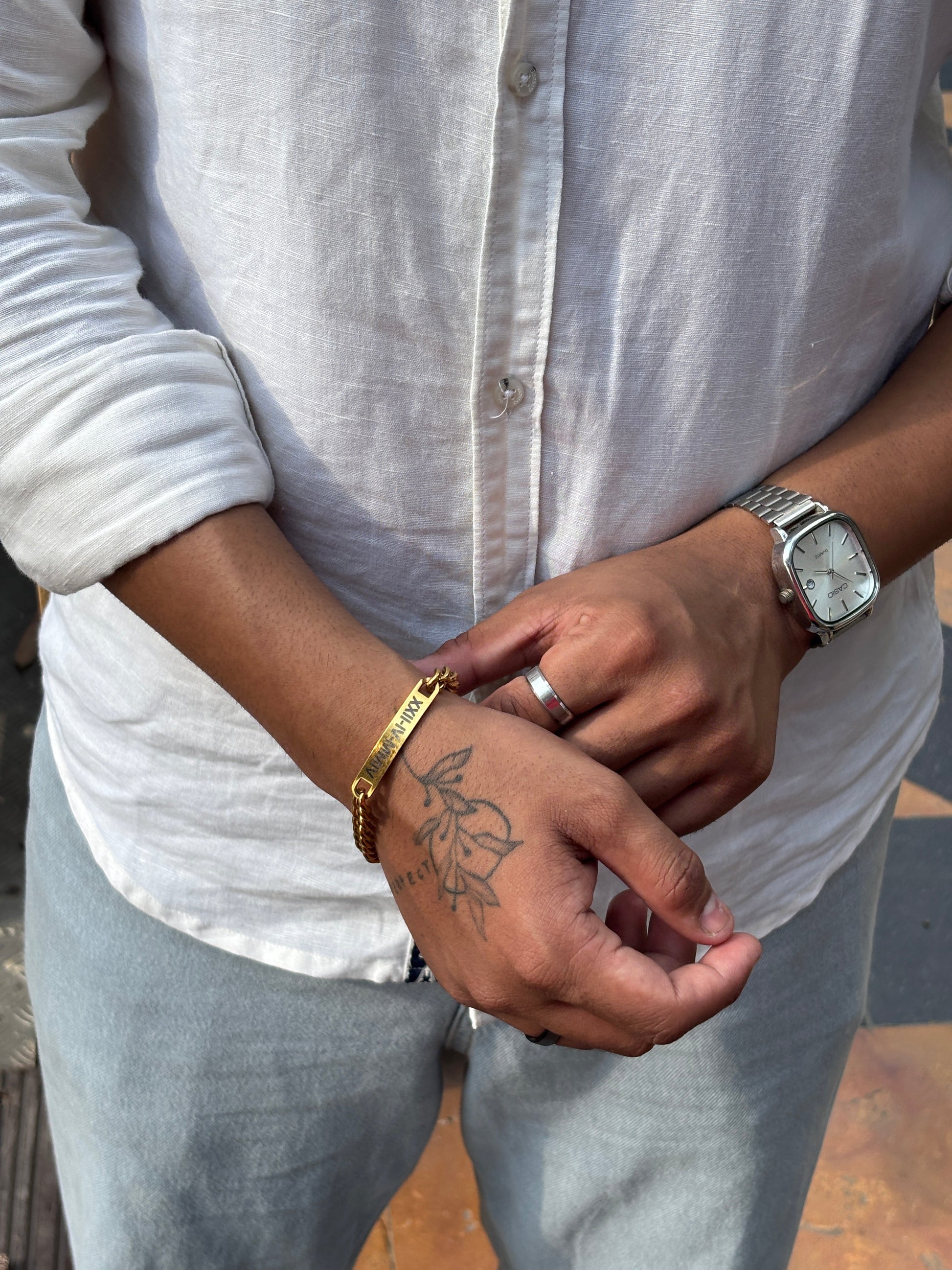 Elegant Lustre of Love gold bar bracelet worn on wrist with a stylish shirt and watch