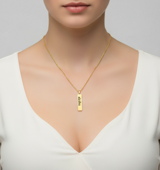 Customizable gold bar pendant necklace with engraved name akshu on a gold chain