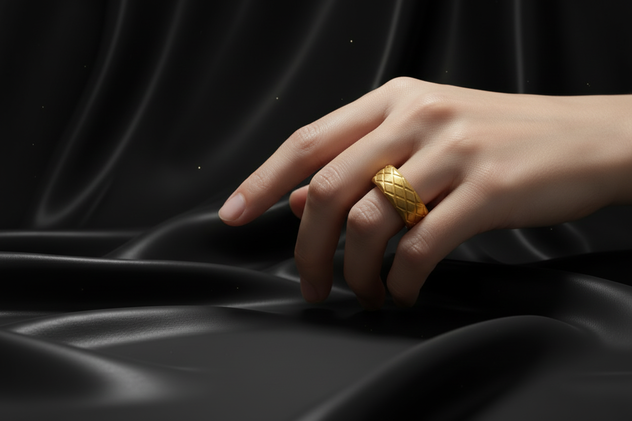 Stylish gold stainless steel ring for men showcased on a hand against dark silky fabric