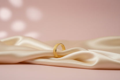Lustre of Love gold stainless steel ring elegantly displayed on silky fabric