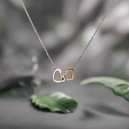 Delicate interlock hearts necklace with two-tone heart pendants on a fine chain