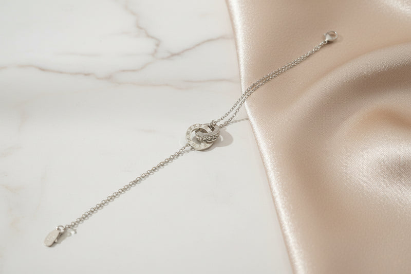 Lustre of Love interlocking circles bracelet stainless steel on a soft satin background