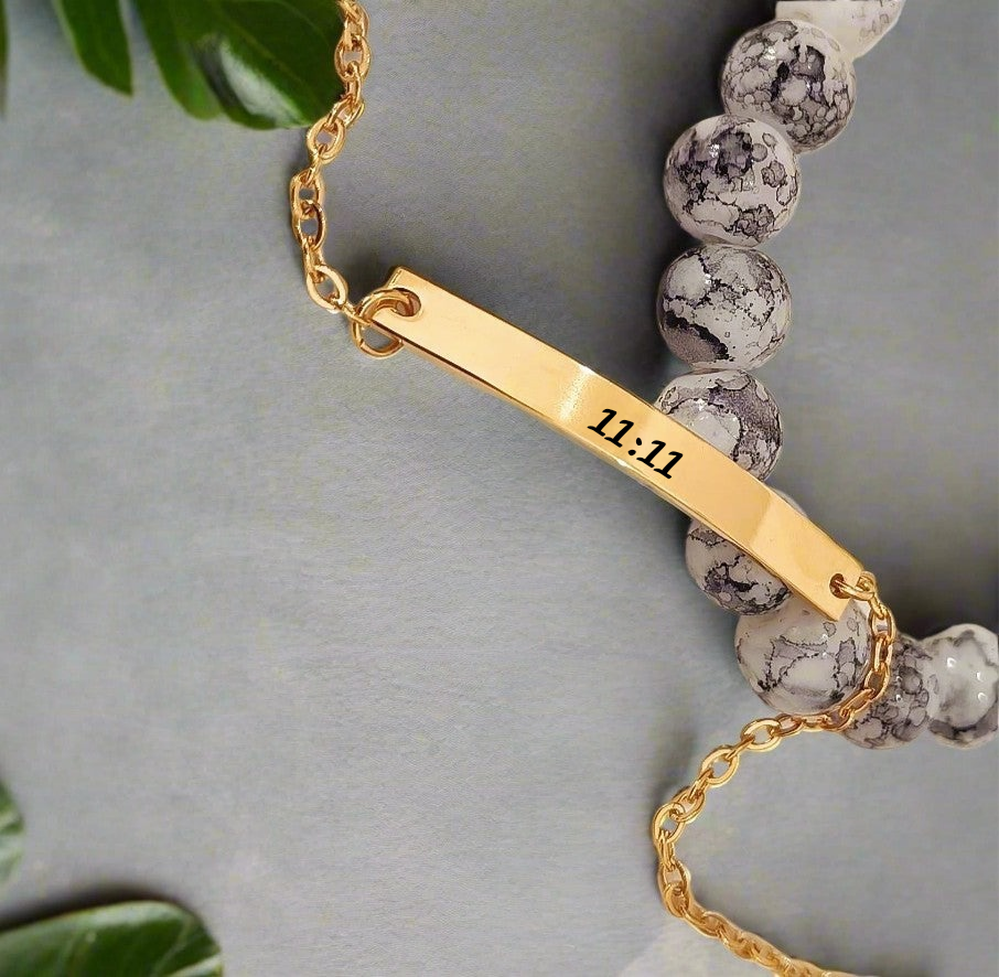Lustre of Love gold bar bracelet with 11:11 engraving and beaded stone detail on gray background