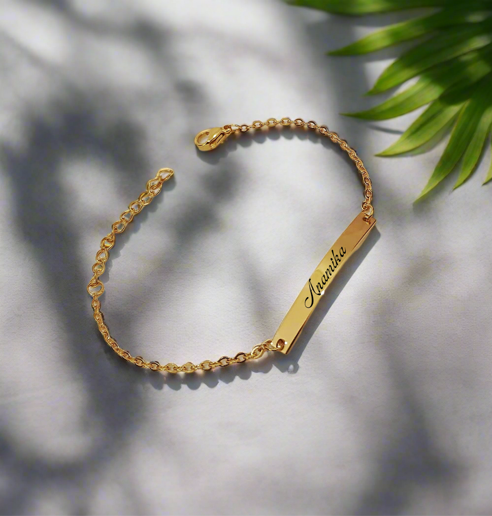 Lustre of Love personalized gold bar bracelet with delicate chain and name engraving on a white surface