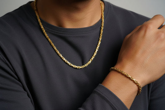 Gold chain and bracelet on a white surface