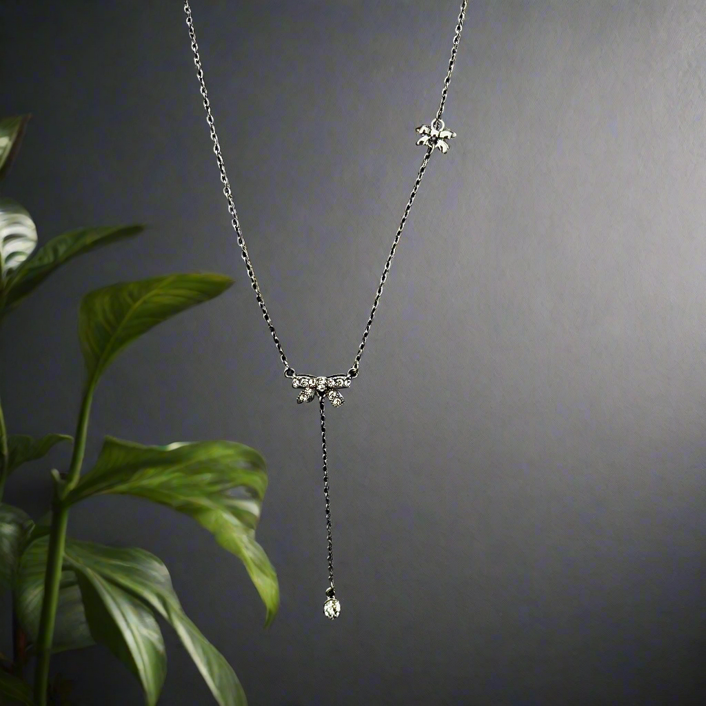 Delicate silver necklace with elegant bow charm and teardrop pendant by Lustre of Love