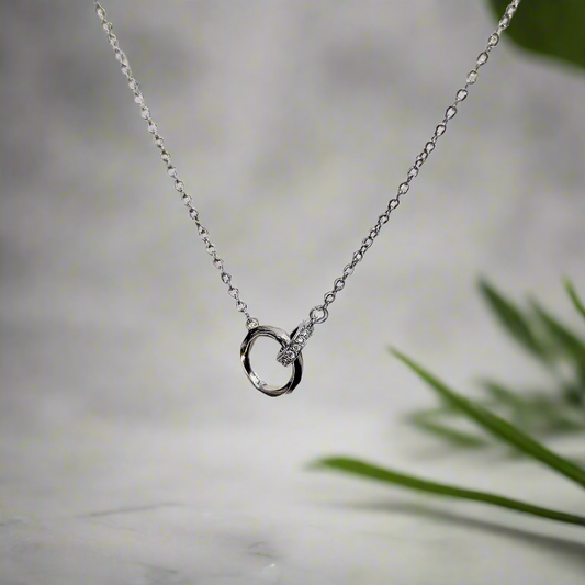 Lustre of Love silver interlocked ring pendant necklace with delicate chain on blurred background