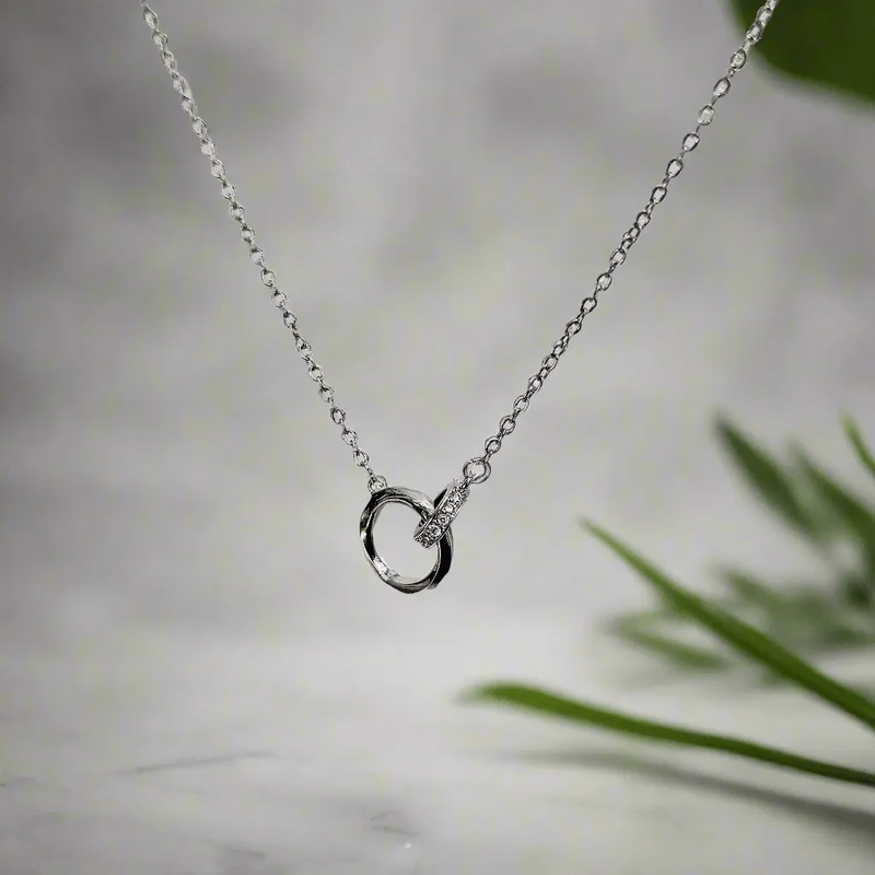 Lustre of Love silver interlocked ring pendant necklace with delicate chain on blurred background