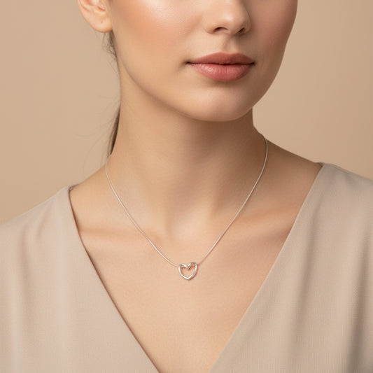 Silver knot heart pendant necklace worn by a model, showcasing elegant design and shine