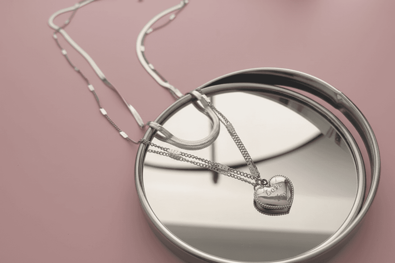 Lustre of Love silver layered heart necklace displayed on a reflective surface
