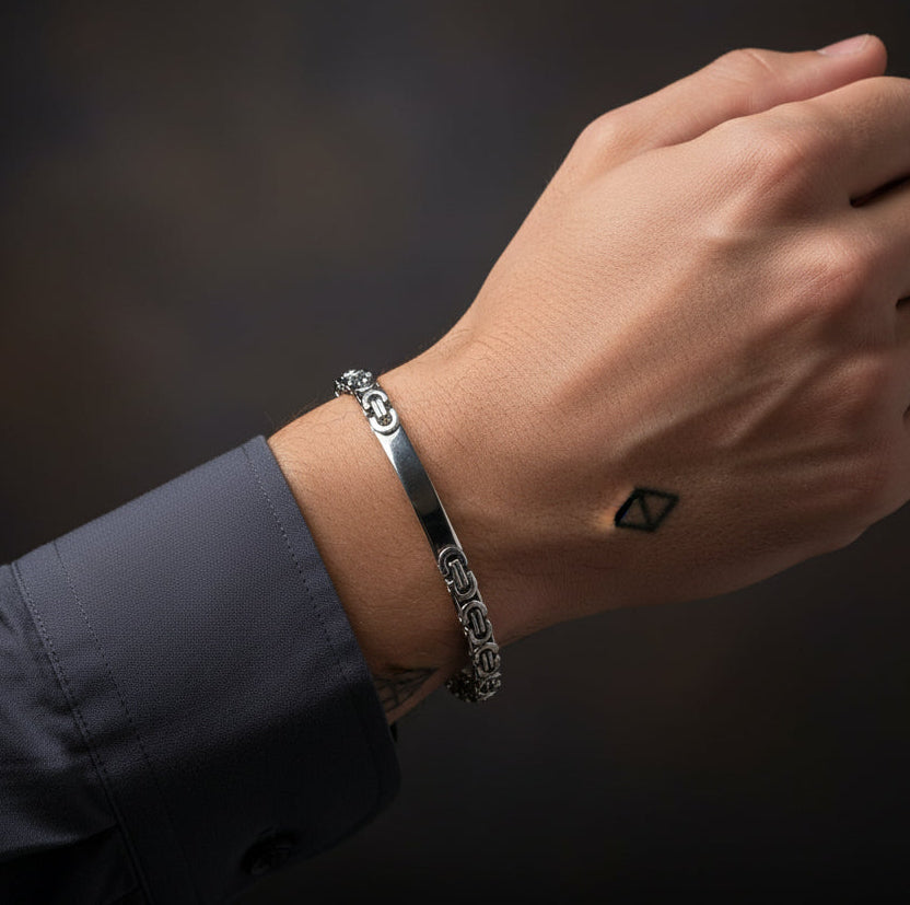 Silver-toned Byzantine bracelet worn on a hand, showcasing its intricate design and elegant finish