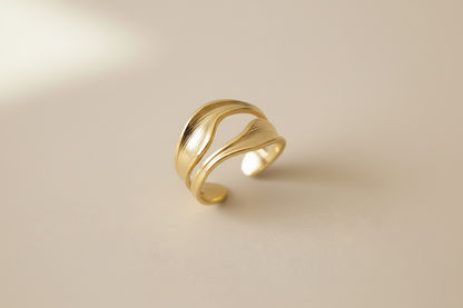 Lustre of Love gold wave ring in an elegant design, featuring a stainless steel adjustable size
