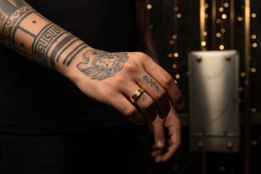 Stylish stainless steel gold ring for men displayed on a tattooed hand